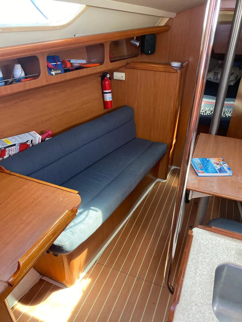 Slide: The Image of Interior of a 2009 Hunter 31-2 sailboat with wooden furnishings and a blue cushioned bench. - 6