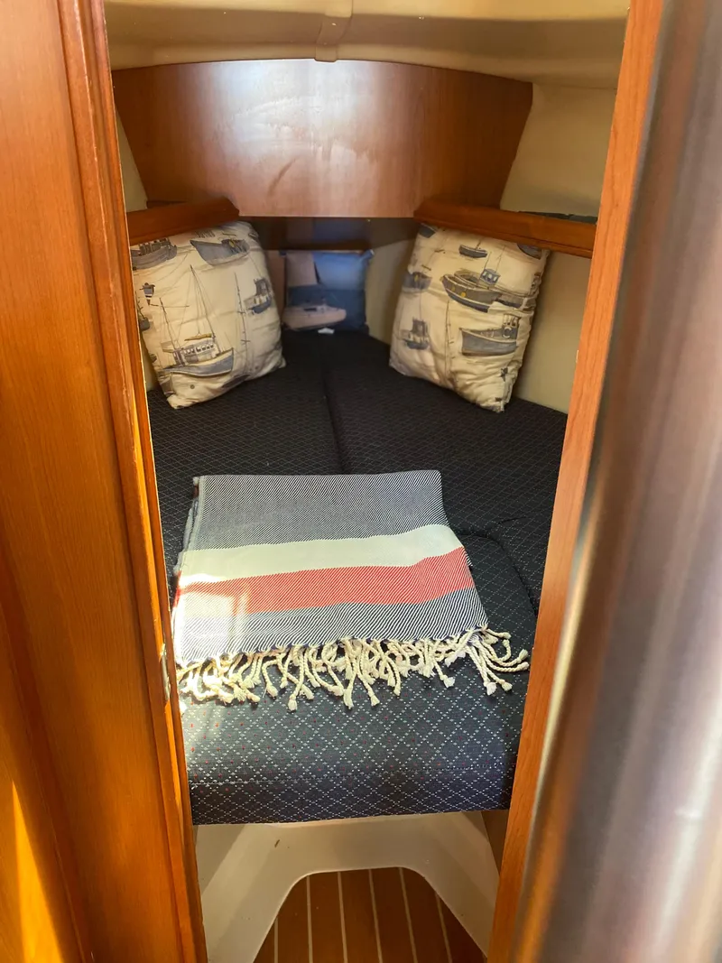 Slide: The Image of Cozy cabin interior of a 2009 Hunter 31-2 sailboat with nautical-themed pillows. - 7