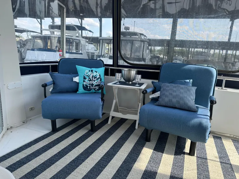 Slide: The Image of 2002 Carver 444 Cockpit Motor Yacht interior with blue chairs and striped rug. - 10