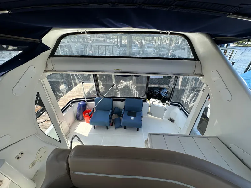 Slide: The Image of 2002 Carver 444 Cockpit Motor Yacht interior with seating area and marina view. - 12