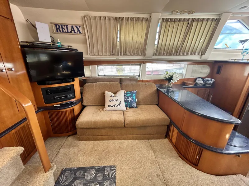 Slide: The Image of Interior of 2002 Carver 444 Cockpit Motor Yacht with cozy seating area and entertainment center. - 16