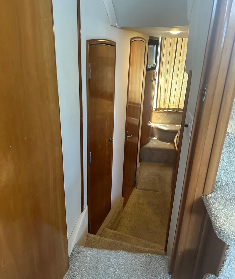 Slide: The Image of Interior hallway of 2002 Carver 444 Cockpit Motor Yacht with wooden doors and carpeted stairs. - 21