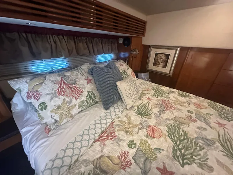 Slide: The Image of Cozy bedroom in 2002 Carver 444 Cockpit Motor Yacht with nautical-themed bedding. - 25