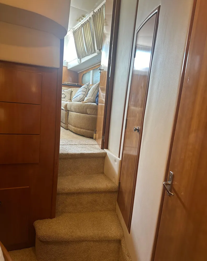 Slide: The Image of Interior of 2002 Carver 444 Cockpit Motor Yacht with carpeted stairs and wooden cabinetry. - 31