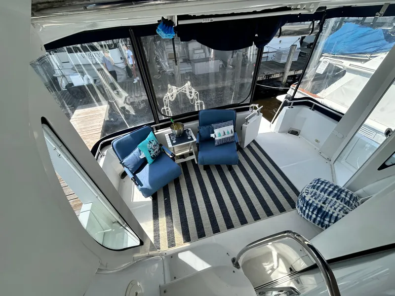 Slide: The Image of 2002 Carver 444 Cockpit Motor Yacht interior with seating area and striped rug. - 7