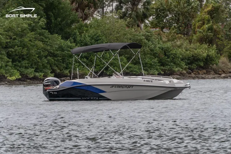 Slide: The Image of 2022 Starcraft SVX 171 OB boat on water with lush greenery in the background. - 2