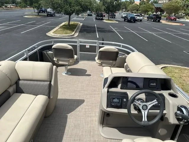 Slide: The Image of 2024 Sun Tracker Fishin' Barge 20 DLX pontoon boat interior in parking lot. - 2