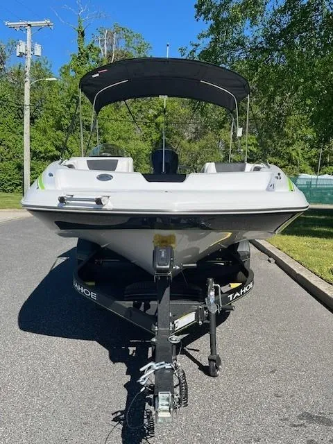 Slide: The Image of 2024 Tahoe 2150 boat with canopy on trailer, parked on a sunny day. - 3