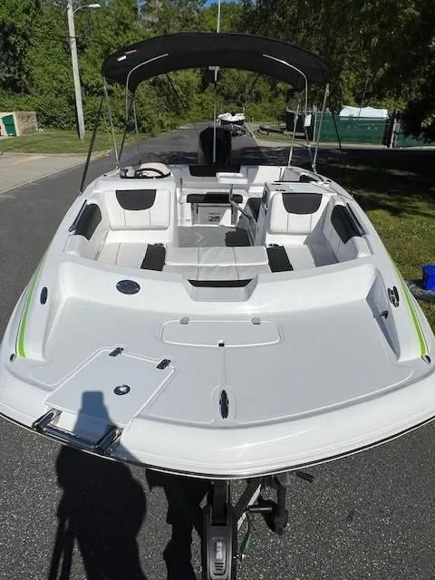 Slide: The Image of 2024 Tahoe 2150 boat with spacious seating and canopy on a sunny day. - 6