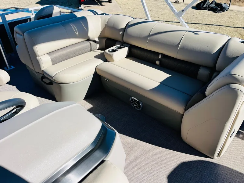 Slide: The Image of 2024 Sun Tracker Fishin' Barge 20 DLX interior seating area with cup holders and speaker. - 20