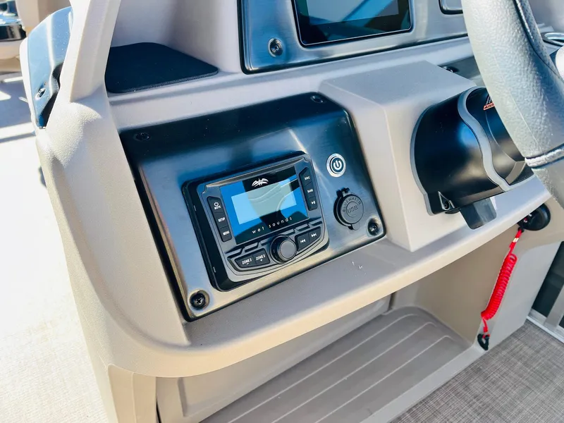 Slide: The Image of 2024 Sun Tracker Fishin' Barge 20 DLX dashboard with control panel and steering wheel. - 28