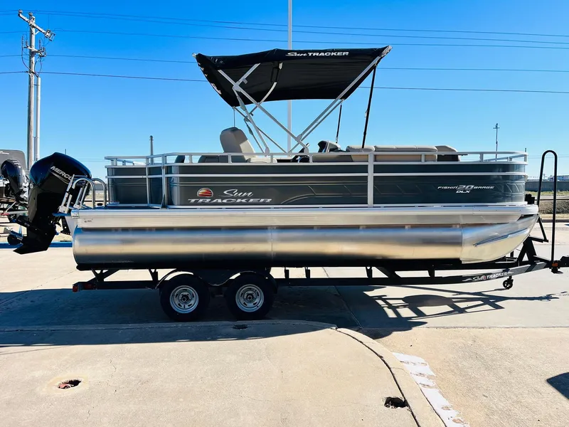 Slide: The Image of 2024 Sun Tracker Fishin' Barge 20 DLX pontoon boat on a trailer. - 3