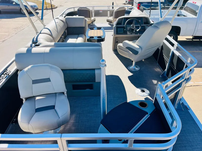 Slide: The Image of 2024 Sun Tracker Fishin' Barge 20 DLX pontoon boat interior with seating and steering console. - 8