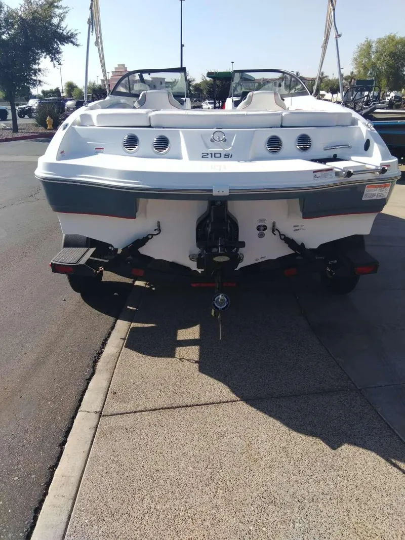 Slide: The Image of 2024 Tahoe 210 Si boat rear view in a parking lot. - 2