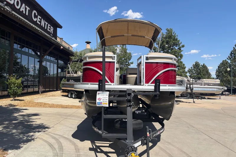 Slide: The Image of 2024 Sun Tracker Party Barge 22 RF XP3 pontoon boat displayed at a boat center. - 2