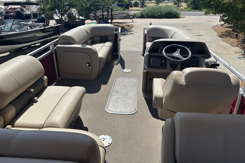 Slide: The Image of 2024 Sun Tracker Party Barge 22 RF XP3 interior with beige seating and steering console. - 7