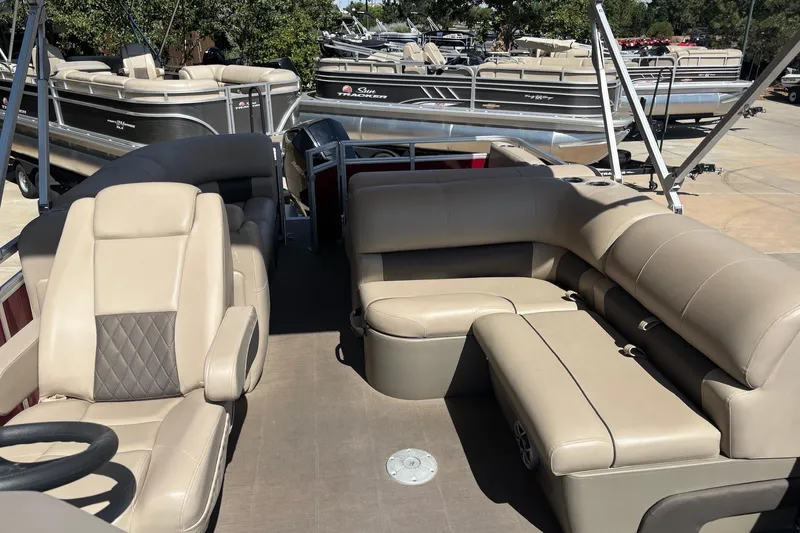 Slide: The Image of 2024 Sun Tracker Party Barge 22 RF XP3 with beige seating, docked among other boats. - 4