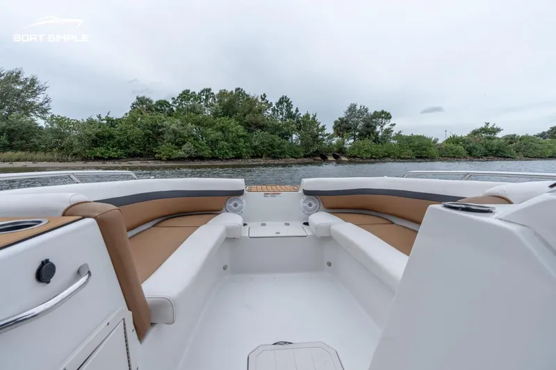 Slide: The Image of 2022 Starcraft SVX 211 OB boat interior with tan seating, near a scenic shoreline. - 5