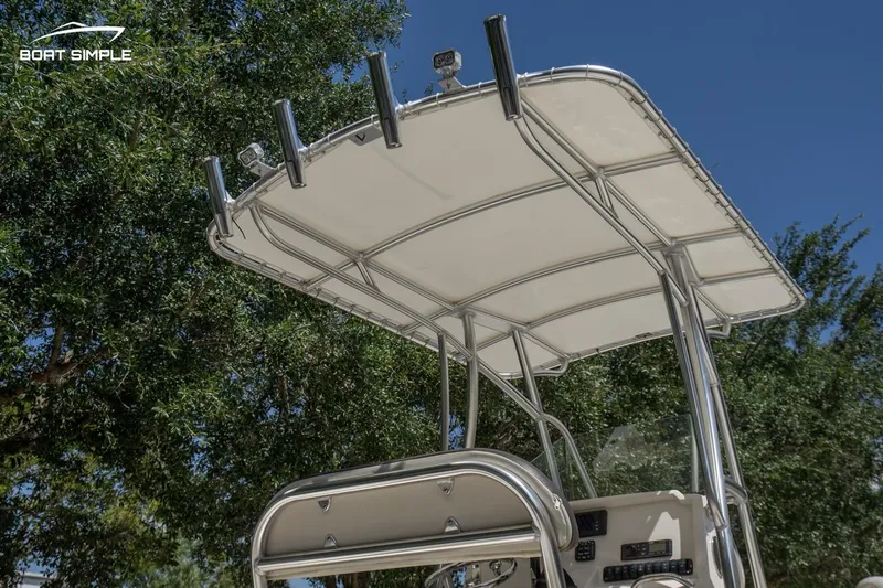 Slide: The Image of 2023 Sailfish 220 CC boat with T-top canopy against a clear blue sky. - 14