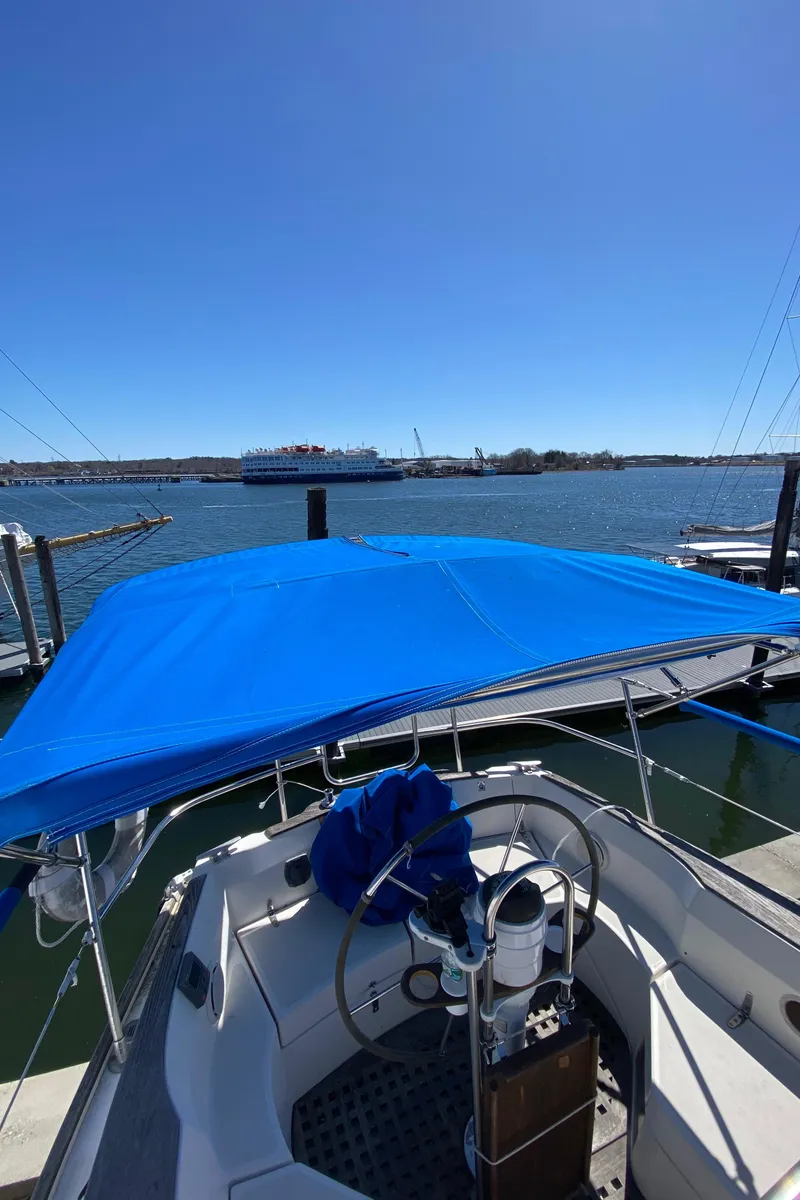 Slide: The Image of 1985 Sabre 32 sailboat with blue canopy docked at marina. - 12