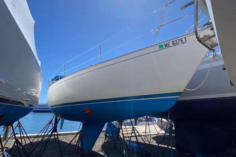 Slide: The Image of 1985 Sabre 32 sailboat on stands, docked at a marina. - 2