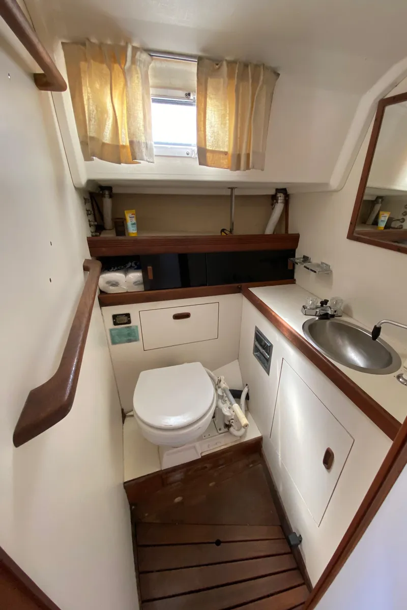 Slide: The Image of 1985 Sabre 32 sailboat bathroom with sink, toilet, and wooden accents. - 21