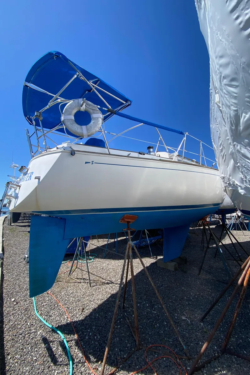 Slide: The Image of 1985 Sabre 32 sailboat on dry dock with blue hull and canopy. - 4