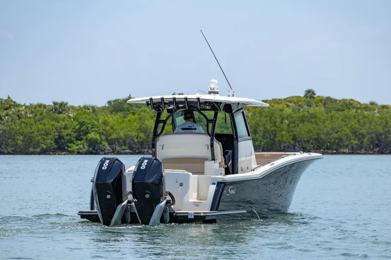 Slide: The Image of 2022 Scout 330 LXF boat with dual outboard engines on calm water. - 3