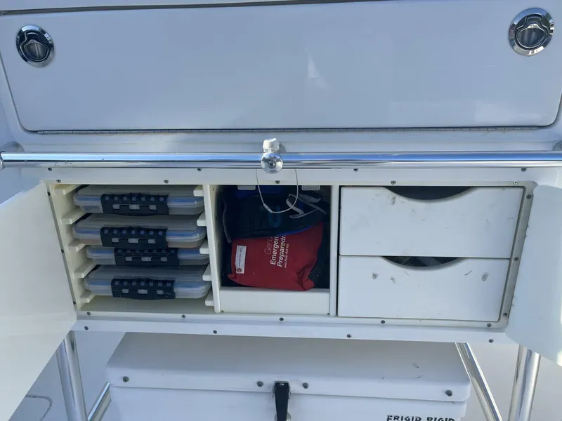 Slide: The Image of Storage compartment on a 2016 Invincible 36 CC boat with tackle boxes and safety gear. - 12