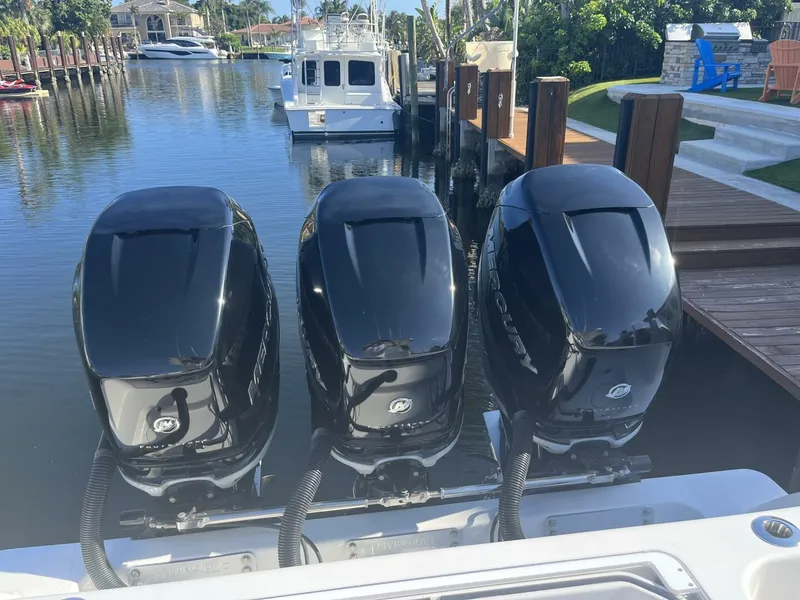 Slide: The Image of Triple Mercury outboard engines on a 2016 Invincible 36 CC boat docked in a marina. - 18