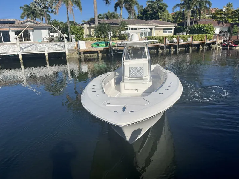 Slide: The Image of 2016 Invincible 36 CC boat docked in a calm residential marina. - 2