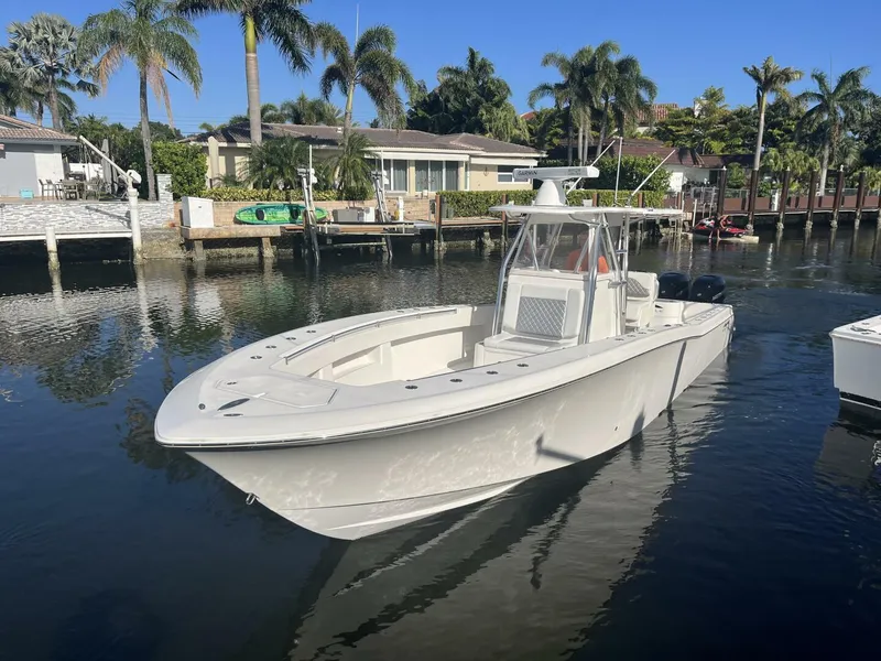 Slide: The Image of 2016 Invincible 36 CC boat docked in a scenic waterfront area. - 3