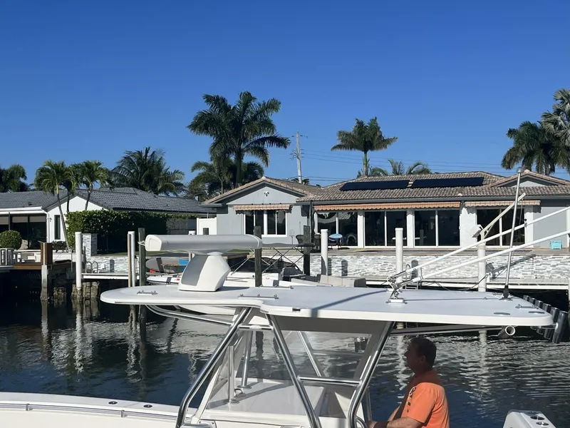 Slide: The Image of 2016 Invincible 36 CC boat docked near waterfront homes with palm trees. - 7