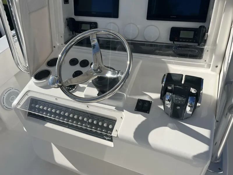 Slide: The Image of 2016 Invincible 36 CC boat helm with steering wheel and control panel. - 8