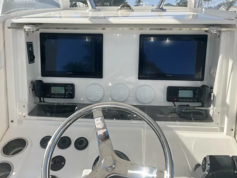 Slide: The Image of 2016 Invincible 36 CC boat dashboard with dual screens and navigation controls. - 9