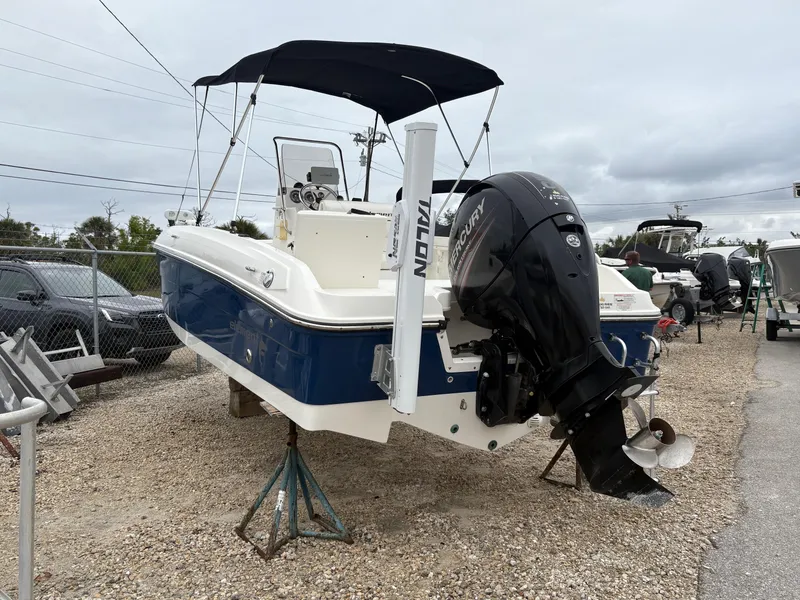 Slide: The Image of 2018 Bayliner F21 boat with outboard motor on display in a gravel lot. - 3
