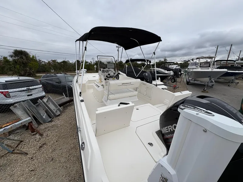 Slide: The Image of 2018 Bayliner F21 boat with canopy, parked outdoors, featuring a Mercury engine. - 5