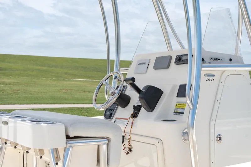 Slide: The Image of 2021 Cobia 201 Center Console boat helm with steering wheel and controls. - 14