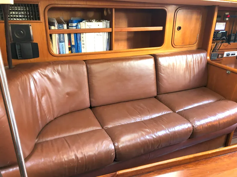 Slide: The Image of Nautor Swan 36-2 1988 yacht interior with brown leather sofa and wooden shelves. - 8