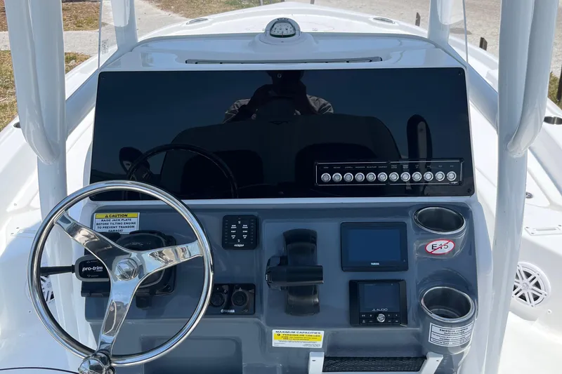 Slide: The Image of 2024 Tidewater 2210 Carolina Bay boat dashboard with steering wheel and electronic controls. - 11