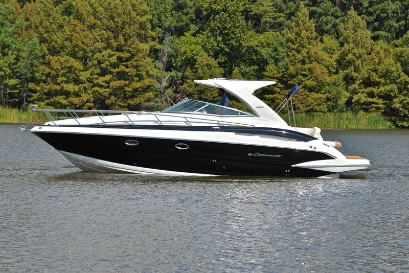 Slide: The Image of 2020 Crownline 350 SY boat cruising on a lake with forested background. - 11