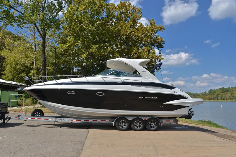 Slide: The Image of 2020 Crownline 350 SY boat on a trailer by a lake. - 16