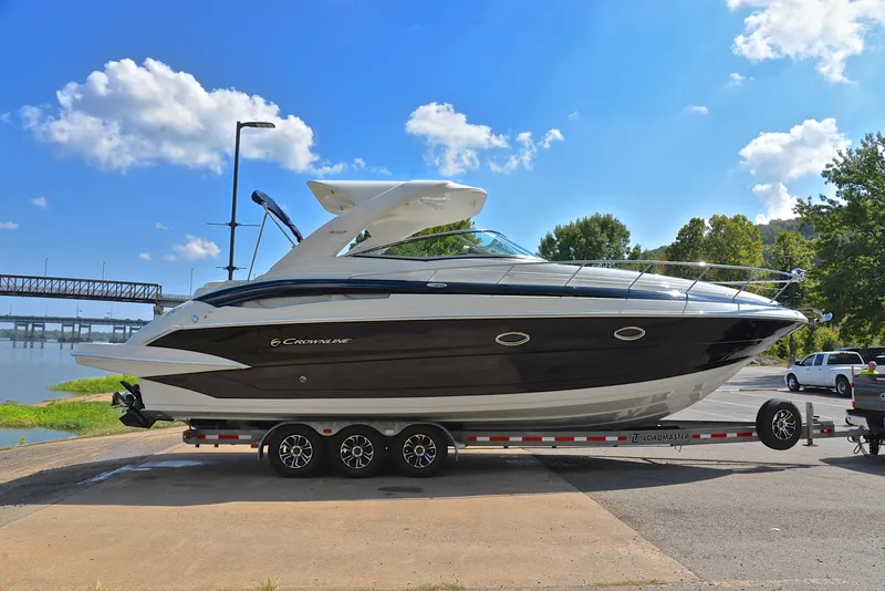 Slide: The Image of 2020 Crownline 350 SY boat on a trailer by a river. - 20