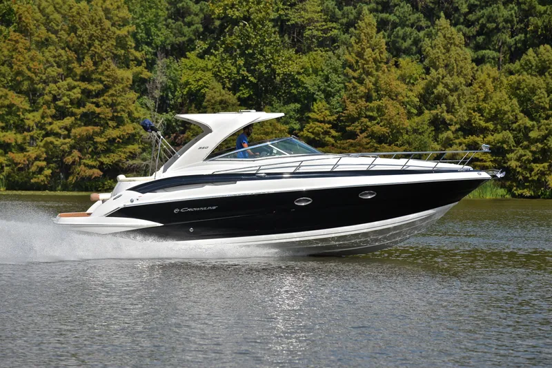 Slide: The Image of 2020 Crownline 350 SY cruising on a lake with forested background. - 3