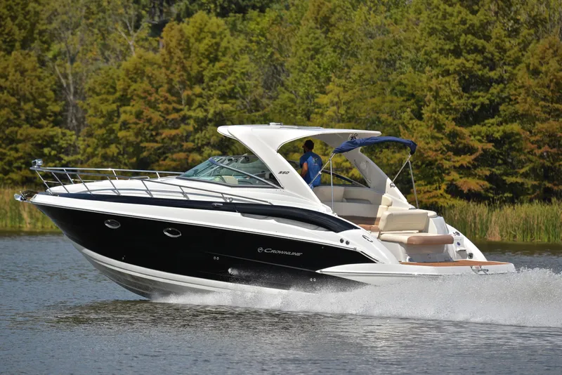 Slide: The Image of 2020 Crownline 350 SY cruising on a lake with lush green trees in the background. - 4