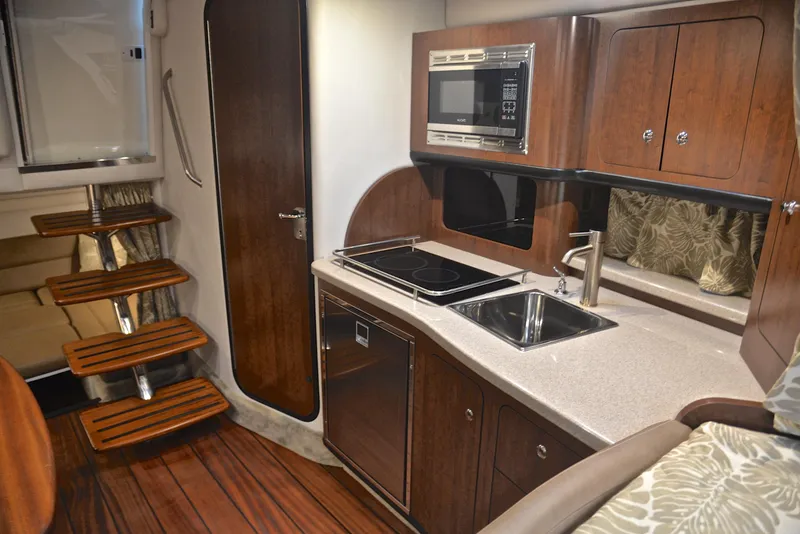 Slide: The Image of Modern kitchen area in 2020 Crownline 350 SY yacht with wooden cabinetry and stainless steel appliances. - 43