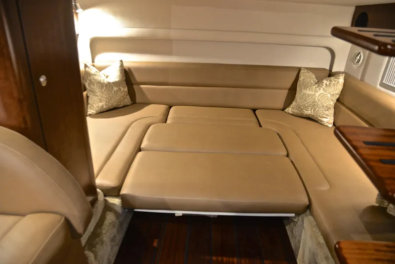 Slide: The Image of 2020 Crownline 350 SY cabin interior with beige seating and decorative pillows. - 47