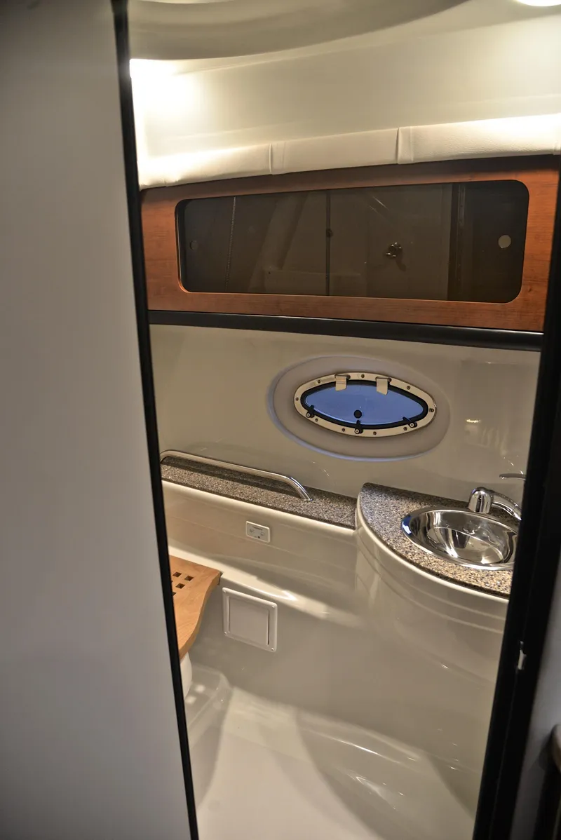 Slide: The Image of 2020 Crownline 350 SY yacht bathroom with sink and porthole window. - 49