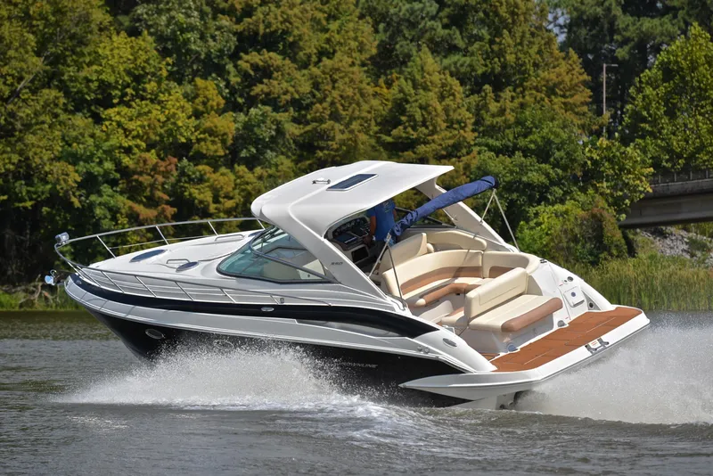 Slide: The Image of 2020 Crownline 350 SY cruising on a lake with lush green trees in the background. - 6