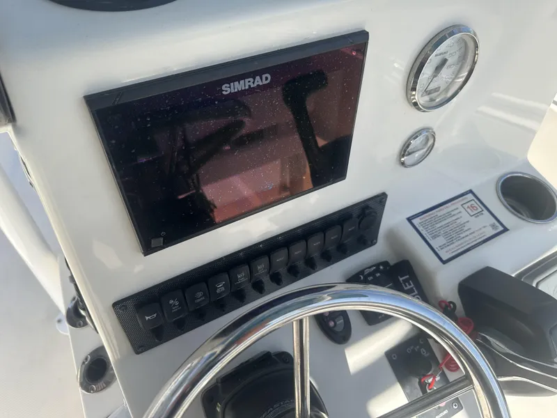Slide: The Image of Bulls Bay 2400 2021 boat dashboard with Simrad display and control panel. - 10